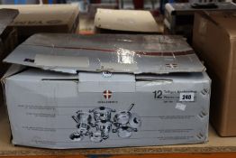 A boxed Global Metals International twelve piece cookware set.