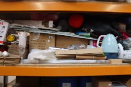 A shelf of household items to include souvenirs and kitchenware.
