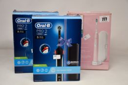 Two as new Oral B Pro 2 black edition electric toothbrushes and a Phillips Sonicare 4300