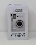 A boxed as new The Adventure Challenge & Lomography Lomo Automat Instant Camera (Box opened).
