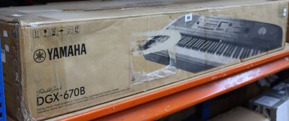 A boxed Yamaha Portable Grand DGX-670B Digital Piano in black.