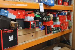 A shelf of assorted car parts to include coil springs, alternators, water pumps, brake discs, timing