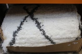 A large rug in white with a grey pattern.