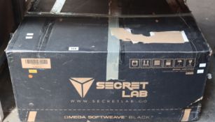 A boxed Secret Lab Omega Softweave Black 3 Gaming Chair.