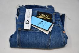 A pair of as new Disney X Gucci Donald Duck cropped jeans (Size 28).