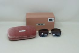 A pair of lady's boxed as new Miu Miu sunglasses (0MU 52RS 124152 52).