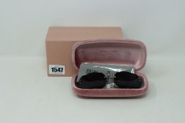 A pair of boxed as new MIU MIU MU06S round framed sunglasses.