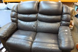 A two-seater black leather sofa.