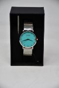 A ladies boxed as new Coluri Watch in turquoise with a spare strap.