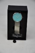 A ladies boxed as new pin-on Coluri Watch in turquoise with a spare strap.