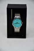 A ladies boxed as new Coluri Watch in turquoise with a spare strap.