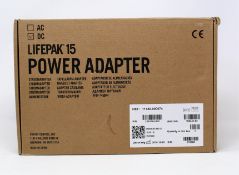 A boxed as new Physio-Control LIFEPAK 15 DC Power Adapter (P/N: 11140-000074) (Box opened, some