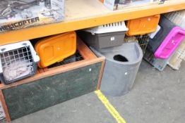 A shelf of pet items and related to include cages, hut and bird feeders.