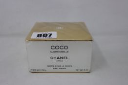 A Chanel Coco Mademoiselle body cream (150g outer box is creased and cellophane has scratch marks).