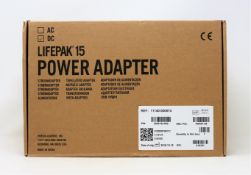 A boxed as new Physio-Control LIFEPAK 15 DC Power Adapter (P/N: 11140-000074) (Box opened, some