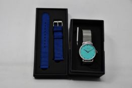 A ladies boxed as new Coluri Watch in turquoise with a spare strap.