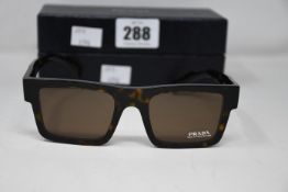A pair of as new Prada sunglasses.