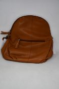 An as new Treats Hannah common natural tan leather back pack bag with dust cover.
