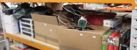 A shelf of miscellaneous items to include puzzles, glasses and Christmas trees.