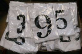 A large quantity of children's Nor-Folk white T-shirts with assorted numbers on front.