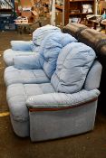 A blue two seater sofa together with an arm chair.