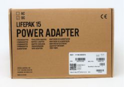 A boxed as new Physio-Control LIFEPAK 15 DC Power Adapter (P/N: 11140-000074) (Box opened, some