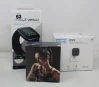 A Fitbit Versa 2 smartwatch, a B Link mini indoor camera and a pair of Covesun wireless headphones.