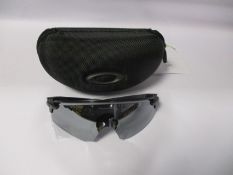 A pair of as new Oakley sunglasses.