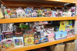 Two shelves of assorted as new toys/games and related items to include Hot Wheels, Toy Story,
