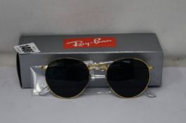 A pair of as new Ray Ban Round metal sunglasses.