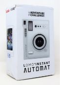 A boxed as new The Adventure Challenge & Lomography Lomo Automat Instant Camera (Box opened, some