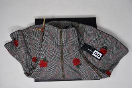 An as new Versace skirt in black/white with embroidered roses (TG 38).