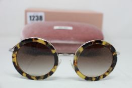 A pair of as new Miu Miu sunglasses.