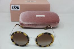 A pair of as new Miu Miu sunglasses.