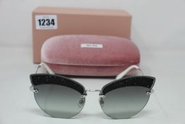 A pair of as new Miu Miu sunglasses.