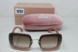 A pair of as new Miu Miu sunglasses.