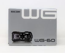 A boxed as new Ricoh WG-60 Digital Camera in Red (Box opened, two pin plug included).