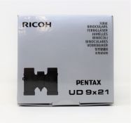 A boxed as new pair of Pentax 9x21 UD Pocket Binoculars in Grey/Orange (Box sealed, some damage to