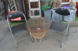 Two Folding Chairs and a Bamboo Glass Topped Table