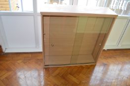 *Shelved Bookcase in Light Oak Finish Enclosed by Sliding Glass Doors