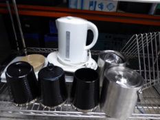 *contents of shelf storage jars plates wine coolers chopping board rack and cordless kettle