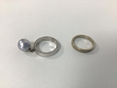 A pair of white metal rings, one with single pearl pendant, the other with inscription to