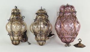 THREE VENETIAN GLASS & METAL FRAMED HALL LANTERNS, comprising a pair in smoky glass, 30cms high, and