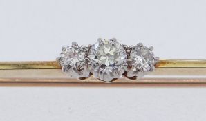 THREE-STONE DIAMOND BAR BROOCH in yellow metal setting, diamond weight 0.2ct overall (visual