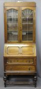 VINTAGE OAK BUREAU BOOKCASE having twin upper leaded glass doors and interior shelves over a