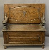 CARVED OAK MONK'S BENCH with crouching lion arms and linenfold front detail on bun feet, 99cms H