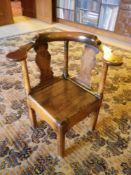 ANTIQUE ELM CORNER FARMHOUSE ELBOW CHAIR having a curved back with twin shaped splats and turned