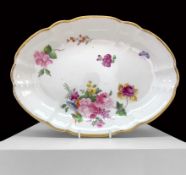 A NANTGARW PORCELAIN OVAL DISH of lobed form and decorated with a large off-centre spray of flowers,