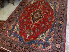 TABRIZ RUG, indigo and beige medallion on a deep red field, royal blue, ivory and salmon