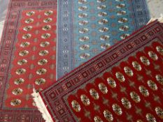 THREE MODERN AFGHAN-STYLE RUGS, identical Bakhara designs in pink, red and teal fields, 170 x 120cms